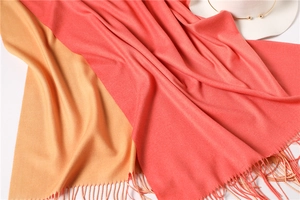 Close-up of pink and yellow cashmere-like scarf showing soft texture and tassel detail