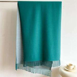 Detail of dark green and light gray reversible scarf with soft fringe and fine texture