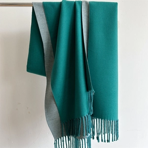 Detail of dark green and light grey double-sided scarf with elegant fringe trim