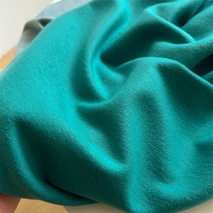 Close-up of soft cashmere-like fabric texture in turquoise with warm brushed finish