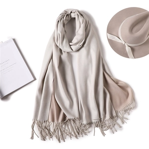 Detailed close-up of soft cashmere-feel scarf with fringe tassels and warm texture