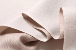 Close-up of soft cashmere-like fabric showing beige texture and thick warm fibers