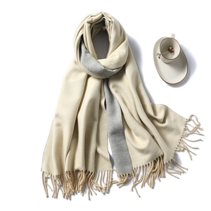 Detail of soft fringe on minimalist cream and grey double-sided cashmere-like scarf