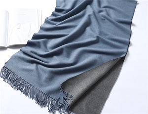 Close-up of blue and gray reversible cashmere-like scarf with fringe details