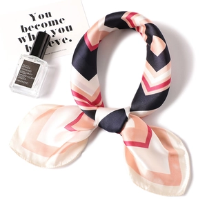 Foulard in seta con motivi geometrici blu e rosa su sfondo bianco piatto