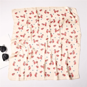 Detail of silk-like square scarf featuring cute cartoon fox and star patterns on satin