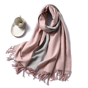 Detail of pink and gray cashmere feel scarf with handmade tassels on white background