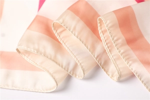 Dettaglio di elegante sciarpa di raso a righe rosa e bianche con cuciture fini e trama morbida