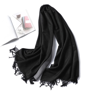 Detail view of the black and grey double-sided cashmere-like scarf with fringe tassels