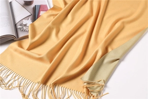 Close-up of soft cashmere-feel scarf detail showing yellow texture and fringe