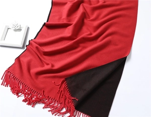 Close-up of dual-sided red and black cashmere-like scarf with thick fringe tassels