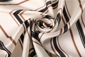 Vista macro di foulard in raso con motivi geometrici e trama liscia effetto seta