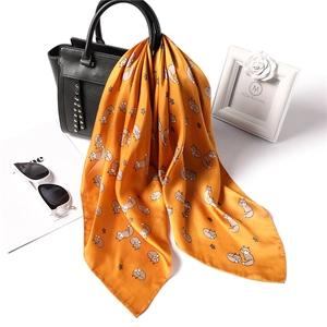 Mustard yellow faux silk scarf with cartoon fox print tied on a black tote bag