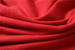 Close-up of soft red cashmere-like fabric texture with elegant folds and fine fluff