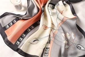 Detail of printed satin scarf featuring floral calla lily patterns and geometric borders