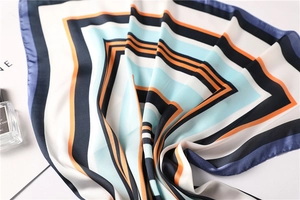 Dettaglio di un foulard in seta a righe geometriche con drappeggio elegante e lucentezza