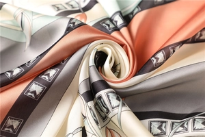 Close-up of silky satin square scarf with elegant geometric patterns and soft drape