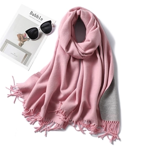 Detail of pink and grey double-sided scarf with fringe and soft knitted texture