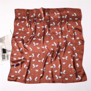 Detail of silk-like square scarf with cartoon fox pattern and satin glossy finish