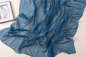 Detalle de bufanda de gasa azul oscuro con textura plisada ligera y costuras finas