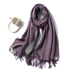 Detail of double-sided purple and grey winter scarf showing thick texture and fringe