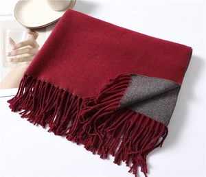Detail of red and grey double-sided cashmere scarf with soft texture and long fringe