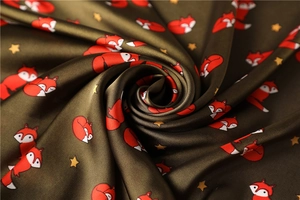 Detailed macro view of olive green faux silk scarf with cartoon fox and stars print