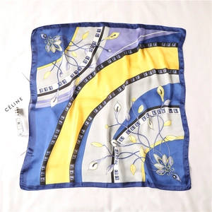Detailed flat lay of a silk square scarf featuring royal blue and yellow lily patterns