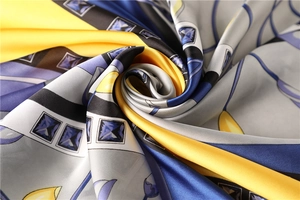 Detailed macro view of the silky square scarf with vibrant floral and geometric patterns