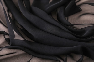 Macro della texture in chiffon nero traslucido con eleganti pieghe effetto seta