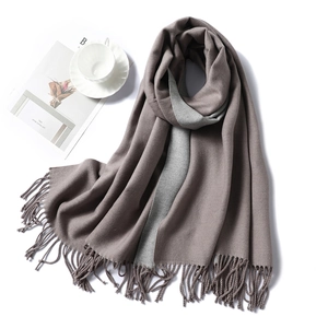 Detail of soft gray and taupe cashmere-like scarf showing thick texture and long fringe