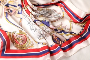 Detailed close-up of nautical silk scarf with anchor and sailboat prints in red white and blue
