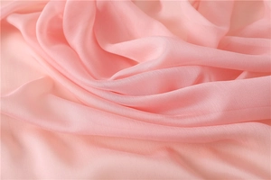 Dettaglio macro del tessuto rosa cipria in chiffon con trama sottile e pieghe morbide