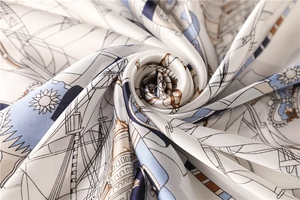 Detailed view of silk-like square scarf featuring classic nautical patterns and smooth texture