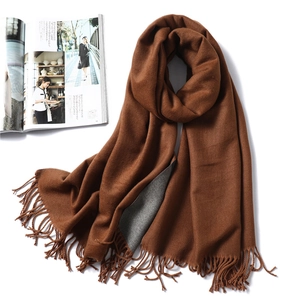 Detail of thick double-sided cashmere-like scarf with fringe and soft texture
