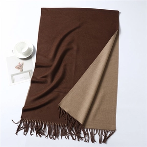 Detail of two-tone brown cashmere-like scarf with long tassels and thick texture