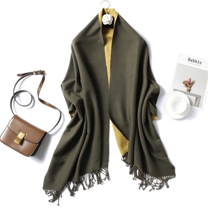 Detail of olive green and yellow double-sided scarf with fine handmade fringe and tassels