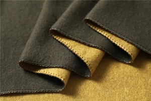 Macro view showing double-sided texture with dark grey and ginger yellow wool fabric