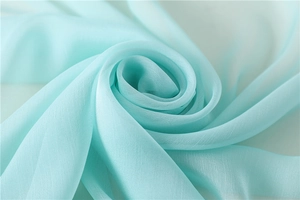 Detalle macro de tela de gasa verde menta transparente con elegante drapeado en espiral