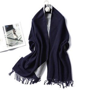 Close-up of double-sided two-tone scarf with fringe details in navy and light grey