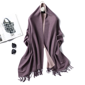 Detail of double-sided two-tone scarf with soft tassels and premium thick texture
