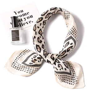 Detailed close-up of leopard print satin silk scarf with elegant knotting and soft texture
