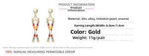 Detail view of gold sunglasses earrings with colorful enamel, pearls, and product dimensions