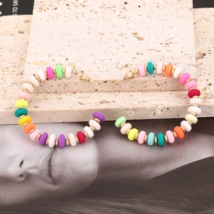Bohemian C-shaped hoop earrings with colorful clay beads on textured stone base
