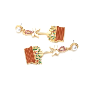 Détail de boucles d'oreilles pot de fleurs émaillé avec strass rose et perle