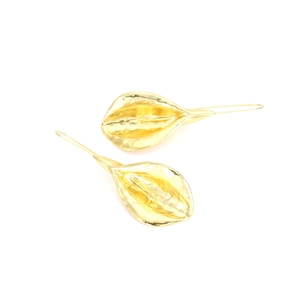 Close-up of golden floral leaf earrings featuring a hammered metal texture and hook design