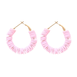 Bohemian gold hoop earrings featuring vibrant pink polymer clay beads on white background