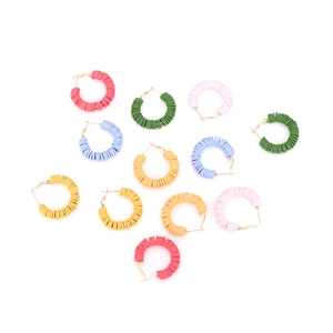 Close-up of vibrant handmade heishi clay bead hoop earrings in various colors