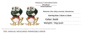 Detailed view of frog earrings made of zinc alloy with green enamel and red rhinestones