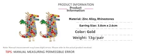 Détail de boucles d'oreilles dinosaures en cristal coloré avec base dorée et strass